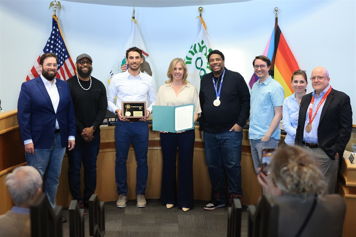 Brian Straw, Chibuike Enyia, Emery Lehman, Vicki Scaman, Cory Wesley, Derek Eder, Jenna Leving Jacobson and Jim Taglia pose in Council Chambers as Lehman receives key to the Village.