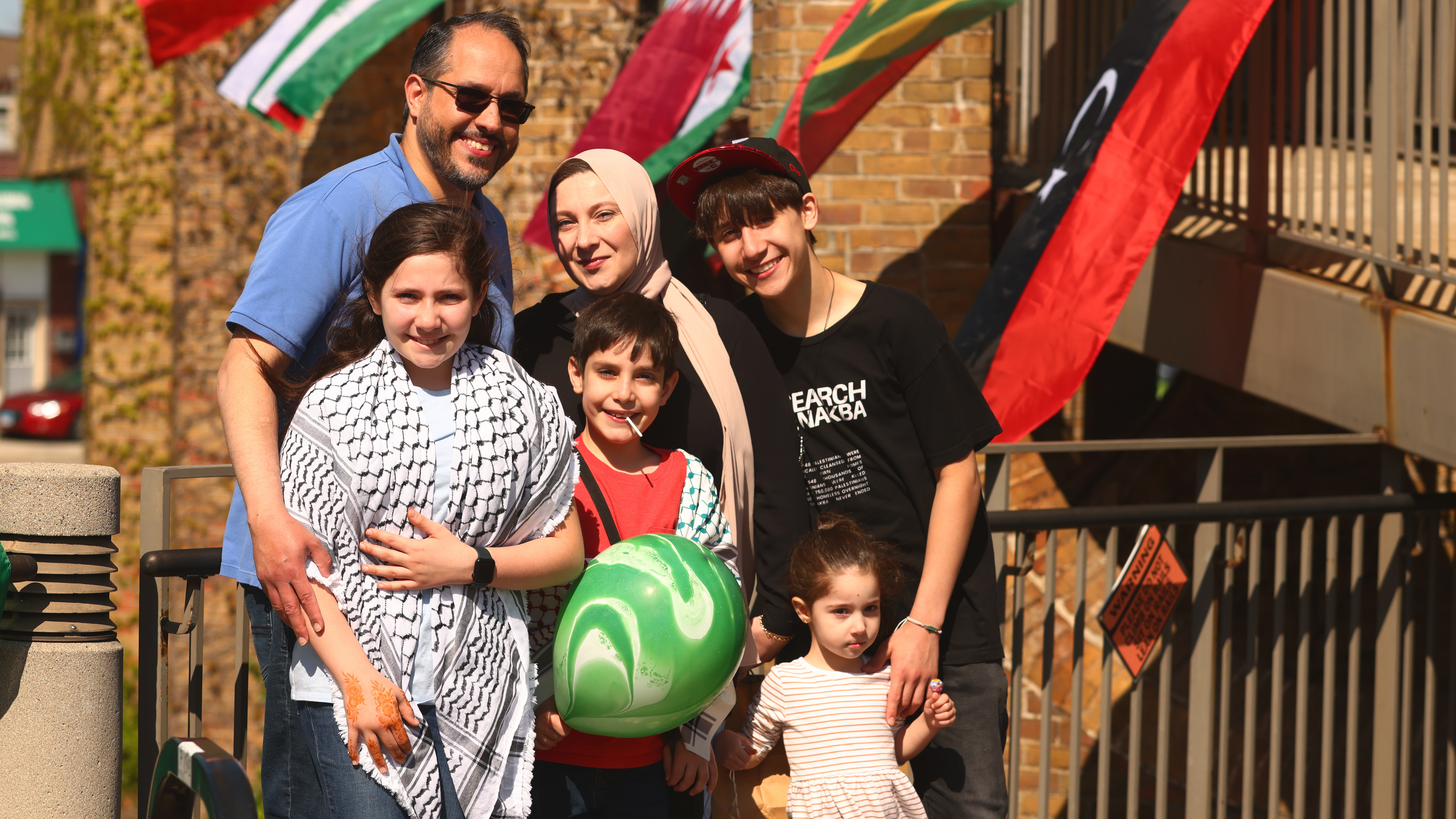 A family of six people pose for a photo in the courtyard at Oak Park's Village Hall during the 2025 Arab American Heritage Month celebration