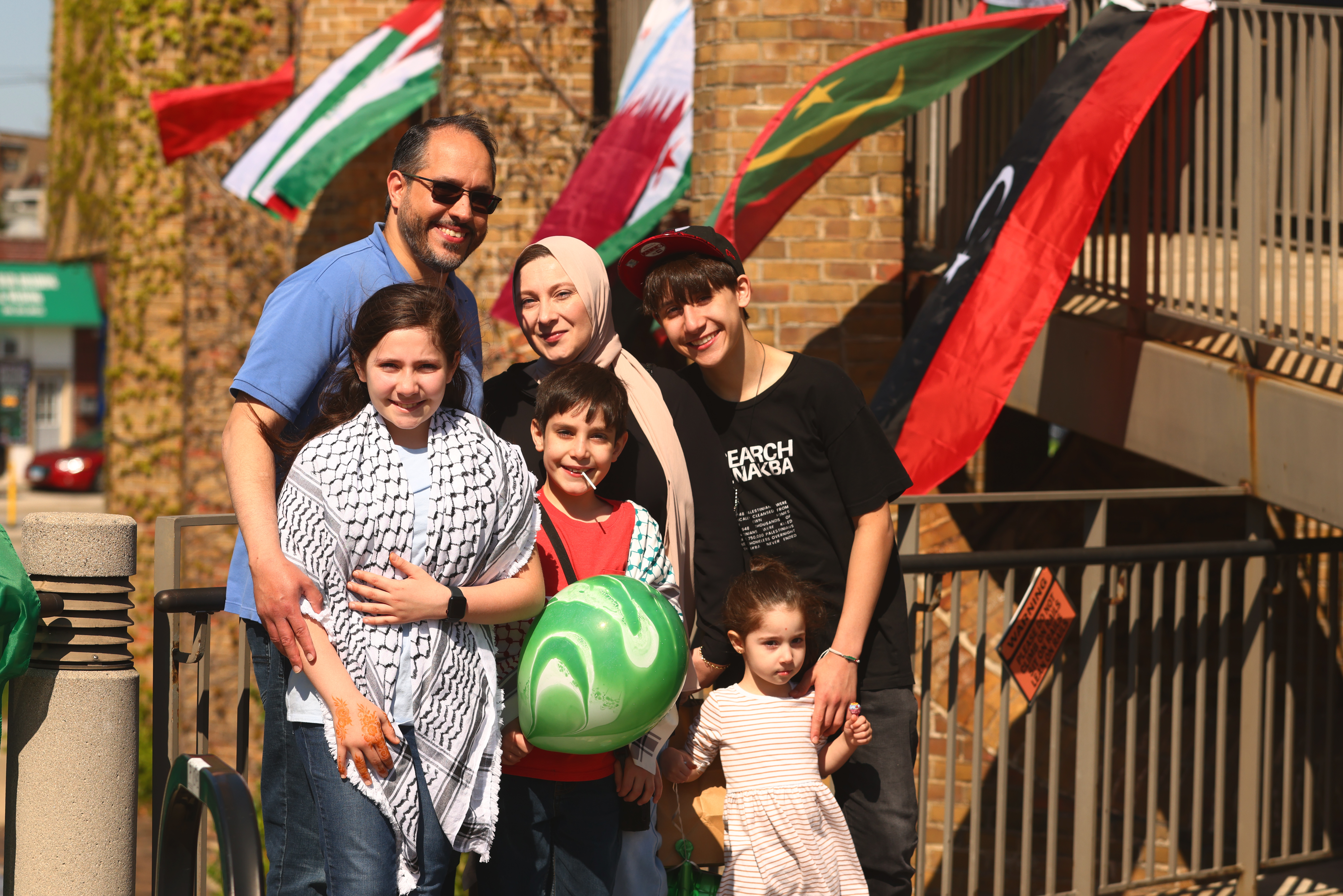 Six people posing in courtyard of Village Hall during Arab America Heritage celebration in 2025