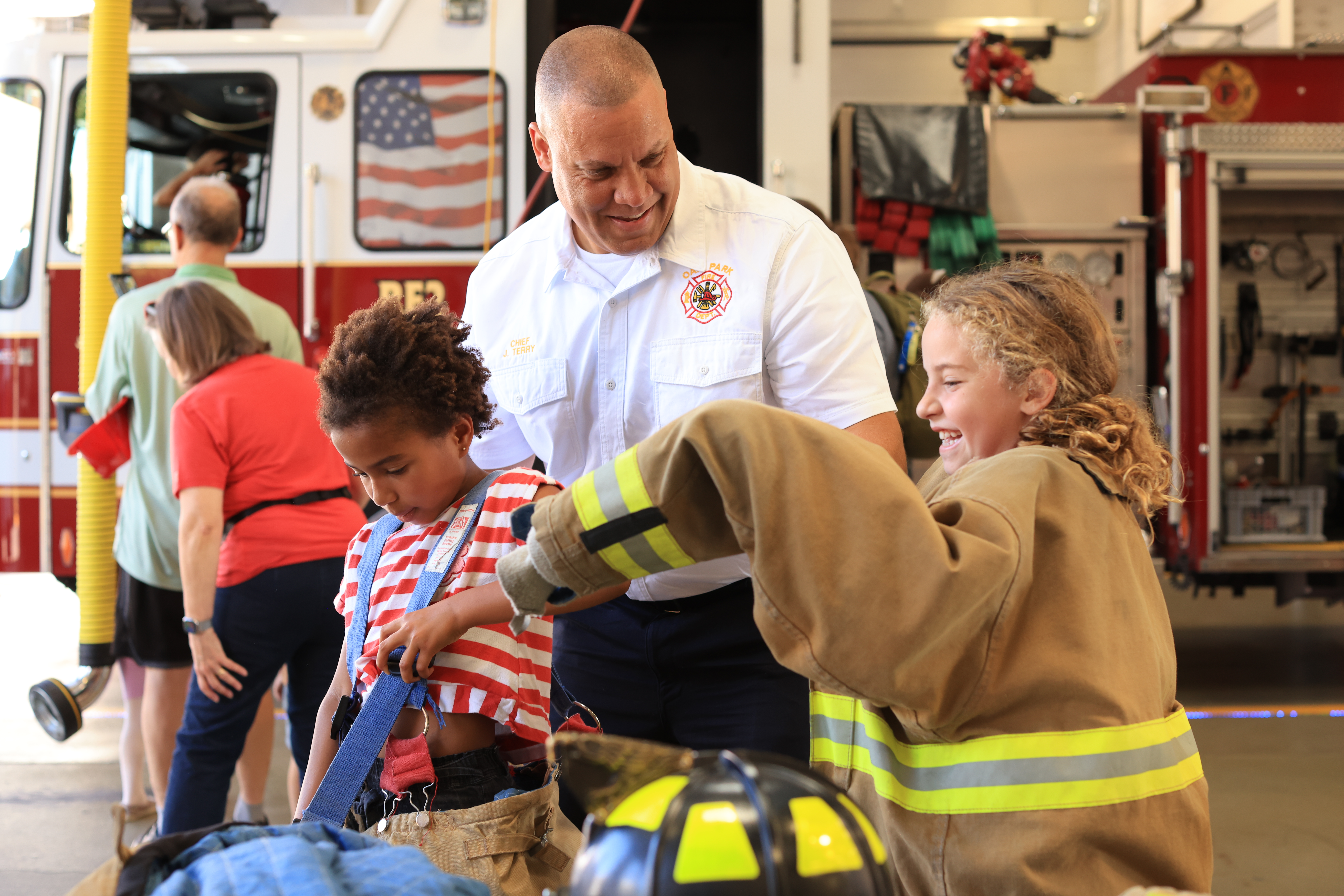 Fire Chief JT Terry watches young people try on gear at fire station